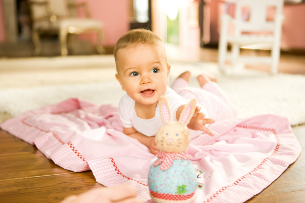 Девочка 5 месяцев играет с плюшевой игрушкой