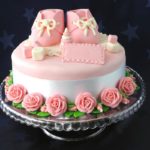 Торт, украшенный розовыми пинетками и розами