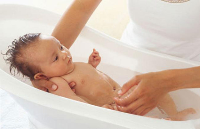 Купание новорождённого в белой ванночке