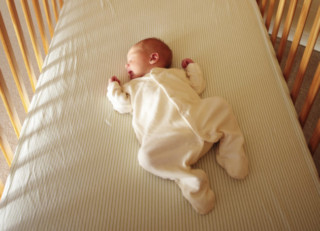 Спящий младенец в кроватке