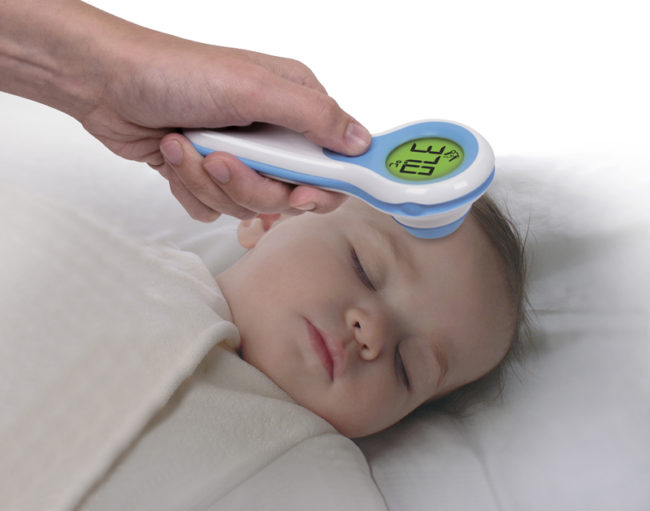 Измерение температуры у новорождённого ребёнка инфракрасным электронным градусником у лба