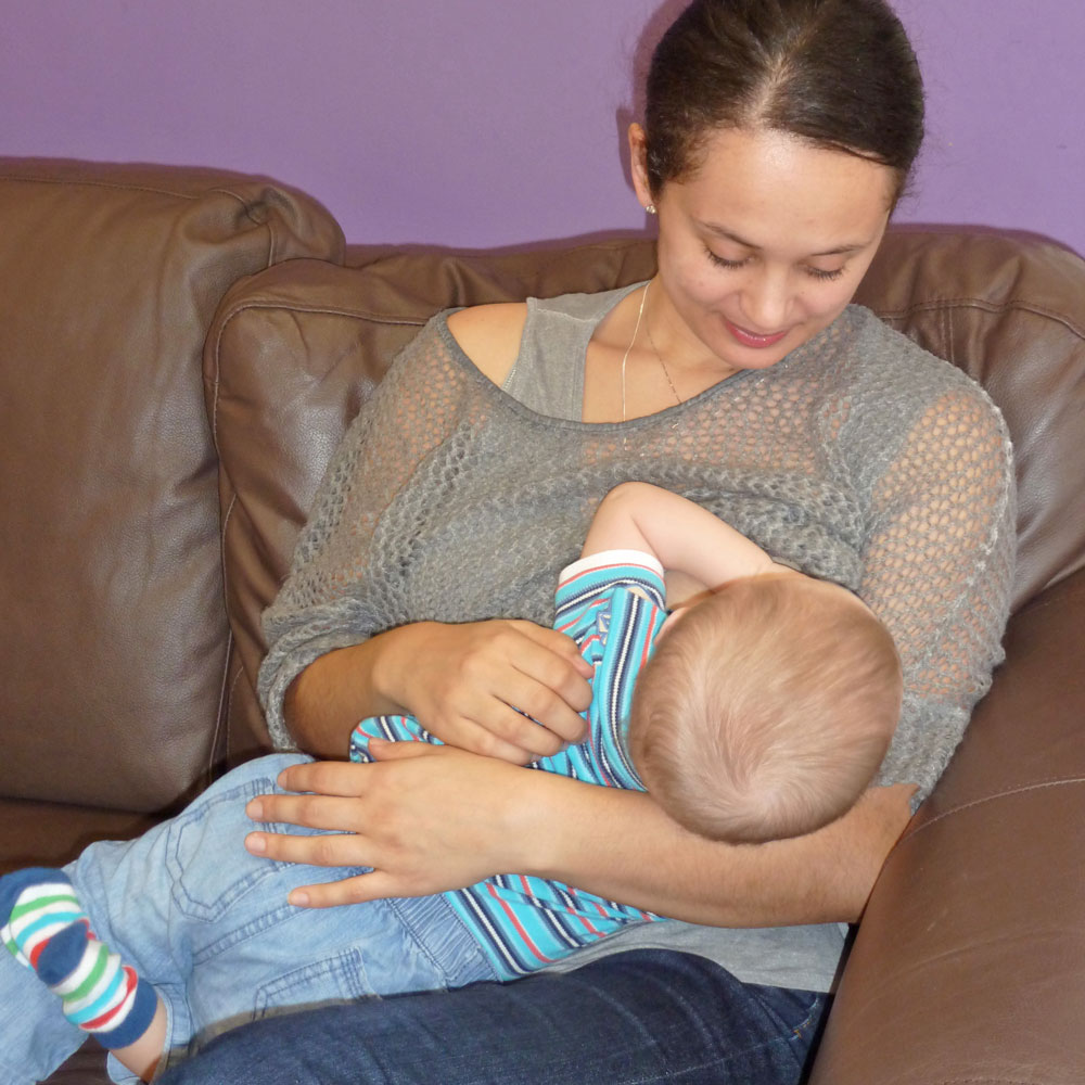 mother breastfeeding older baby in cradle hold
