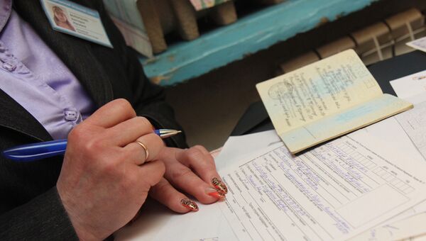 Сотрудница паспортной службы заполняет документы для получения паспорта РФ. Архивное фото