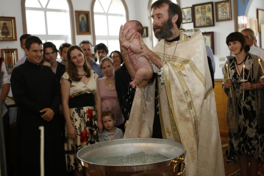 священник крестит малыша