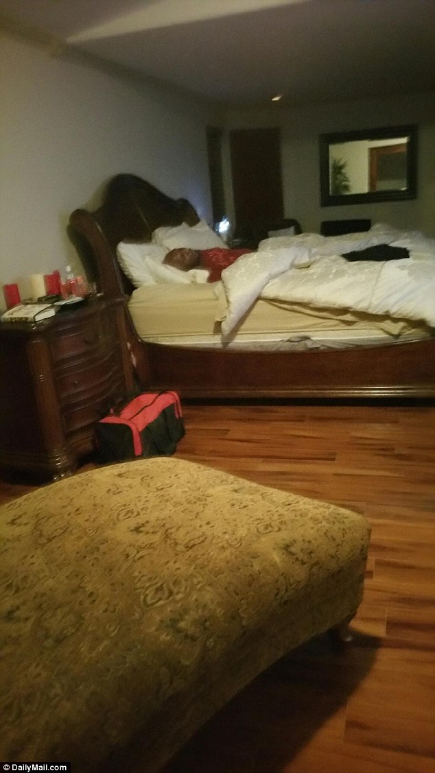 Slumped: Lamar Odom in the king-sized bed where he was found the day after this picture was taken. On the bedside cabinet are what appears to be a copy of Love Ranch owner Dennis Hof