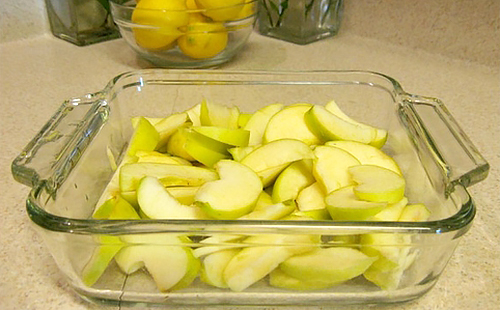Порезанные зелёные яблоки в жаропрочном стеклянном противне