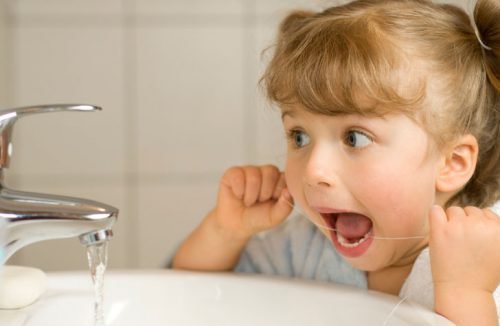 Ребенок и зубная нить для чистки
